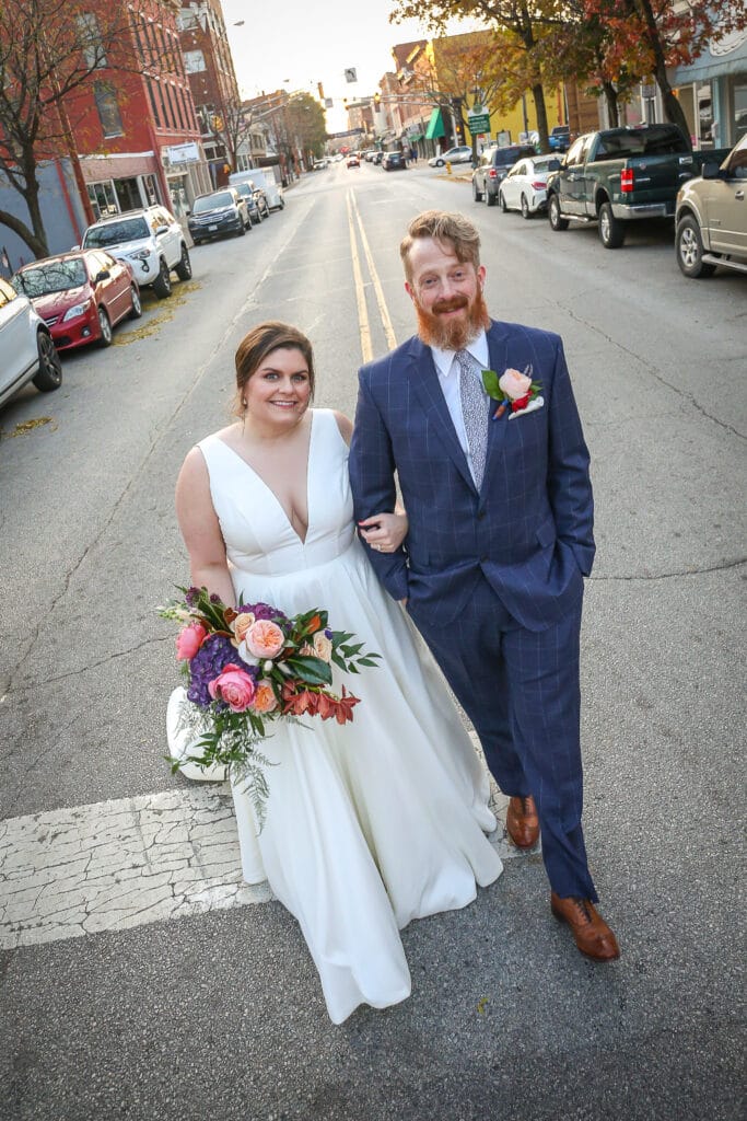 bride and groom pose in middle of the street in downtown lafayette, indiana