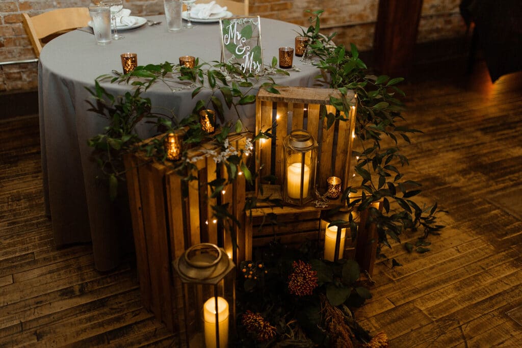 smilax greenery on sweetheart table with lanterns and rustic decor